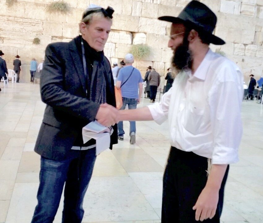 Michael Bolton putting on Tefillin. Credit: humansofjudaism.com via David Kuflik